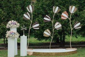 Hochzeit Zeremonie im das Garten. ein luxuriös Hochzeit Zeremonie. romantisch Hochzeit Zeremonie. groß golden Blumen .Die Schränke sind dekoriert mit bunt Blumen. foto