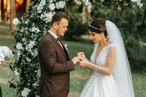 schön Hochzeit Paar auf das Hochzeit Herbst Zeremonie. das runden Bogen ist dekoriert mit Weiß Blumen foto