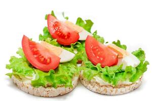 Reis Kuchen Sandwiches mit Tomate, Grüner Salat und Ei - - isoliert auf Weiß. einfach Frühstück. Diät Lebensmittel. schnell und gesund Sandwiches. Knäckebrot mit lecker Füllung. gesund Diät Snack - - Isolierung foto