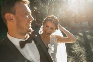 jung Bräutigam und schön Braut mit ein Hochzeit Strauß posieren auf ein Hochzeit gehen im das Wald. jung Familie. foto