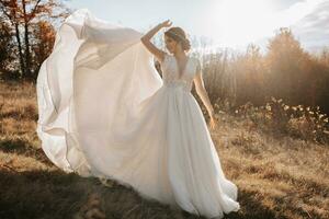 Hochzeit Foto. das Braut und Bräutigam sind Gehen im das Wald. das Braut wirft oben ihr lange Kleid schön. Paar im Liebe. Herbst Hochzeit. foto