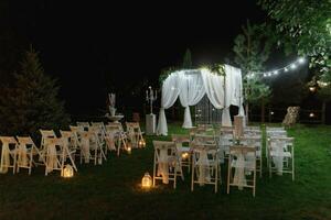 Hochzeit Zeremonie auf das Ufer von das See. Gemälde Zeremonie im das Abend. romantisch malen. das Präsidium ist dekoriert mit Weiß Blumen. Weiß Stühle foto