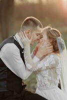 Hochzeit Foto im Natur. das Bräutigam sitzt auf ein hölzern Stand, das Braut steht Nächster zu ihn, gelehnt auf seine Schulter. aussehen beim jeder andere. Porträt von das Braut und Bräutigam