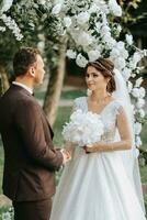 schön Hochzeit Paar auf das Hochzeit Herbst Zeremonie. das runden Bogen ist dekoriert mit Weiß Blumen foto