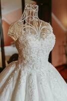 ein exquisit Hochzeit Kleid auf ein Mannequin ist im das Braut Zimmer mit ein königlich Innere. Foto von hoch Qualität