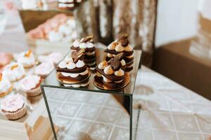 ein köstlich Hochzeit. Süßigkeiten Bar zum ein Bankett. Feier Konzept. modisch Nachspeisen. Tabelle mit Süßigkeiten, Süßigkeiten. Süßigkeiten Bar im Rosa Stil foto