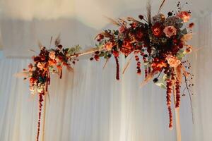 das Hochzeit Tabelle von das Braut und Bräutigam, dekoriert mit rot Blumen, Blau Velours, ist gemacht im rot und Blau. Blumen auf steht. Hochzeit Einzelheiten. Licht foto