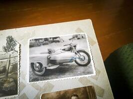 schließen oben Schuss von ein alt schwarz und Weiß Bild von ein Jahrgang Motorrad im ein Foto Album. Antiquität