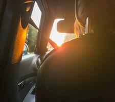 jung blond Frau Fahren das Auto gegenüber das Sonnenuntergang. Konzept foto