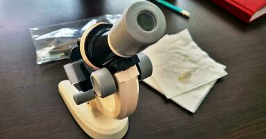 Schuss von das Mikroskop auf das Tisch. Wissenschaft foto