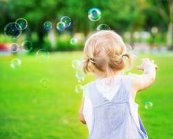 Baby Mädchen abspielen mit Seife Luftblasen foto