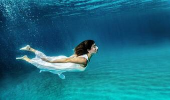 Frau Schwimmen unter Wasser foto