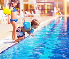 wenig Junge Springen in das Schwimmbad foto