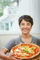 glücklich Teen Junge gekocht Pizza foto