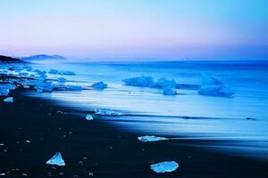 Eisberg auf schwarz Sand Strand von Island foto