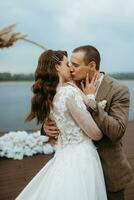 das zuerst Hochzeit tanzen von das Braut und Bräutigam auf das Seebrücke in der Nähe von das Fluss foto