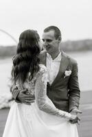 das zuerst Hochzeit tanzen von das Braut und Bräutigam auf das Seebrücke in der Nähe von das Fluss foto