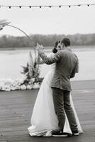 das zuerst Hochzeit tanzen von das Braut und Bräutigam auf das Seebrücke in der Nähe von das Fluss foto