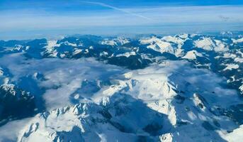 ai generiert Antenne Aussicht von Alpen Berg Angebot mit Schnee und Blau Himmel. foto