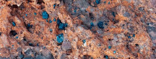 Sandstein texturiert Felsen Hintergrund Foto. Nahansicht Blau verstreut im das braun Stein. foto