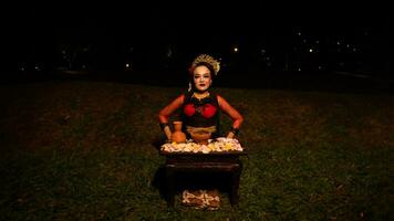 ein weiblich Tänzer führt aus ein Ritual Das schafft ein magisch und mystisch Atmosphäre im Vorderseite von Blume Angebote foto