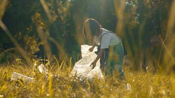 Kind Mädchen Sammlung Plastik Müll im Natur. Kind pflücken oben Müll im Park. foto