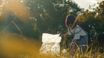 Kind Mädchen Sammlung Plastik Müll im Natur. Kind pflücken oben Müll im Park. foto