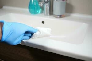 Hand im Handschuhe Reinigung das Badezimmer foto