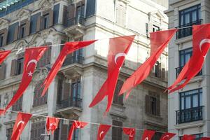 ein niedrig Winkel Schuss von Türkisch National Flagge hängend auf ein Seil im das Straße foto