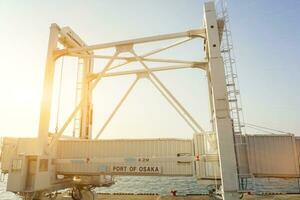 Nahansicht Yacht Passagier Gangway teleskopisch zum wählen oben und fallen aus Yacht Passagiere beim Osaka Hafen auf Sonne Fackel und Blau Himmel Hintergrund. foto