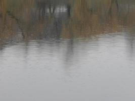 Wasserbeschaffenheit in einem Fluss, Oberfläche im Regen, Flecken foto