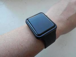 Die elektronische Smartwatch am Handgelenk wird an der männlichen Hand getragen foto