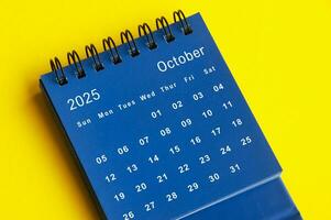 Oktober 2025 Blau Schreibtisch Kalender auf Gelb Startseite Hintergrund. foto