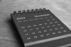 schwarz und Weiß November 2024 Schreibtisch Kalender auf hölzern Schreibtisch. Neu Monat und Kalender Konzept. foto