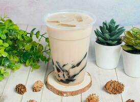 gefroren Milch mit Gras Gelee serviert om Einweg Glas isoliert auf hölzern Tafel oben Aussicht von Hong kong trinken foto