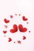 ein Paar von dekorativ Papier Herzen sind umgeben durch Herzen und getrocknet Blumen Vertikale Aussicht foto
