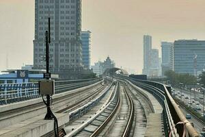 Jakarta, Indonesien, 2023 - - Abend Horizont mit Hochhaus Gebäude und Schiene Transport foto