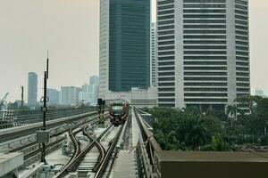 Jakarta, Indonesien, 2023 - - Abend Horizont mit Hochhaus Gebäude und Schiene Transport foto