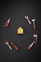 Reparatur oder Zuhause Verbesserung Werkzeuge und ein Haus Modell- auf ein einfach Hintergrund foto
