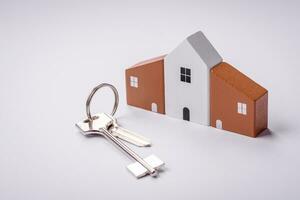 ein klein hölzern Haus und Schlüssel wie ein Idee zum investieren im Ihre besitzen Zuhause foto