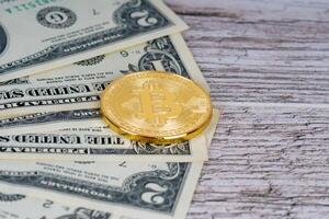 goldene Bitcoin-Metallmünzen und Dollar-Banknoten auf rustikalem Holztisch