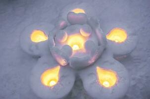 Nahansicht Schnee Kerzen im ein groß Blume gestalten und Schnee Fußboden Hintergrund. Schnee Kerzen sind Aktivitäten von das otaru Schnee Licht Pfad Festival beim otaru, Hokkaido Präfektur, Japan. foto