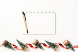 minimale kreative flache Lage der traditionellen Winterweihnachtskomposition und der Neujahrsferienzeit. Ansicht von oben offenes Mockup schwarzes Notebook für Text auf weißem Hintergrund. Mock-up und kopieren Sie Raumfotografie. foto