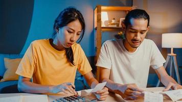 Stress Asia Paar Mann und Frau verwenden den Rechner zur Berechnung des Familienbudgets, der Schulden und der Ausgaben während der Finanzkrise zu Hause in der Nacht. Ehegeldprobleme, Familienbudgetplankonzept. foto
