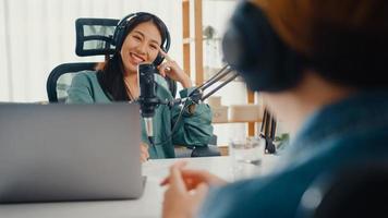 asia girl radio host record podcast verwenden mikrofon tragen kopfhörer interview prominenter gastinhalt gespräch sprechen und in ihrem zimmer zuhören. Audio-Podcast von zu Hause, Sound-Equipment-Konzept.