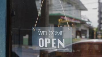 Willkommen, wir haben ein Vintage-Schwarz-Weiß-Retro-Schild an einem Café mit Kaffeeglastür nach der Quarantäne der Coronavirus-Sperrung geöffnet. Inhaber Kleinunternehmen, Essen und Trinken, Geschäftskonzept wiedereröffnet. foto