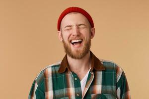 attraktiv jung Mann Lachen mit geschlossen von Freude Augen. gut aussehend männlich Person zeigen seine Zähne während Lachen auf Neu Witz.Glück und positiv Emotionen Konzept foto