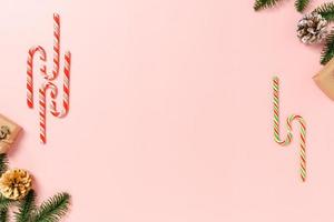minimale kreative flache Lage von traditioneller Weihnachtskomposition und Neujahrsferienzeit. Draufsicht Winterweihnachtsdekorationen auf rosa Hintergrund mit Leerzeichen für Text. Raumfotografie kopieren. foto