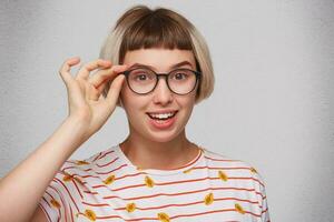 ein Frau tragen Brille und ein gestreift Hemd foto