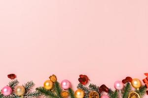 minimale kreative flache Lage von traditioneller Weihnachtskomposition und Neujahrsferienzeit. Draufsicht Winterweihnachtsdekorationen auf rosa Hintergrund mit Leerzeichen für Text. Raumfotografie kopieren. foto